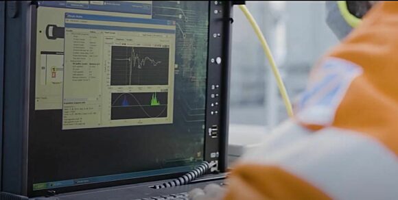 Closeup of workers performing a field test of a substation using mobile inspection tools