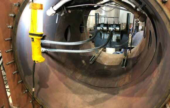 Illuminated interior of  a large pipe mounted with testing equipment