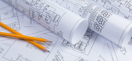 Rolls of electrical design layouts on a desk.