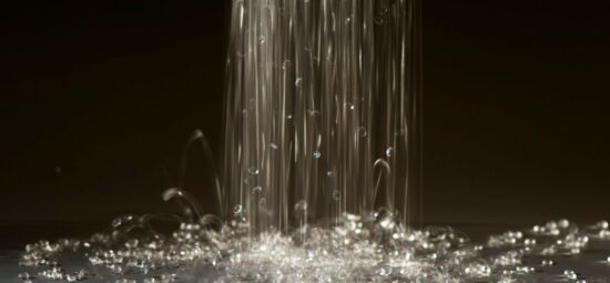 Glass beads cascading onto a flat gray surface.