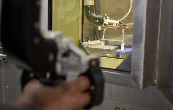 Worker using the remote manipulators of a "warm cell"