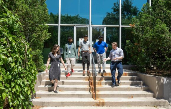 Kinectrics staff descending stairs into courtyard