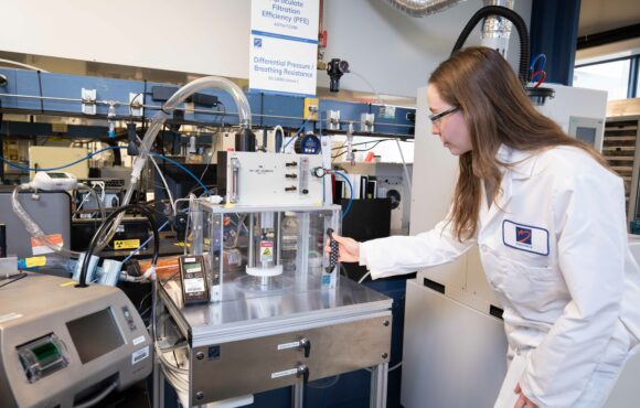 Worker preparing test chamber in Kinectrics particle filtration efficiency lab