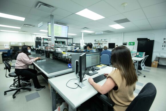 An open office with many engineers working at computer screens.