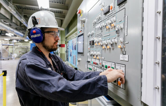 Worker manipulating a control panel