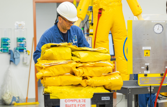 Kinectrics worker carrying yellow protective suits