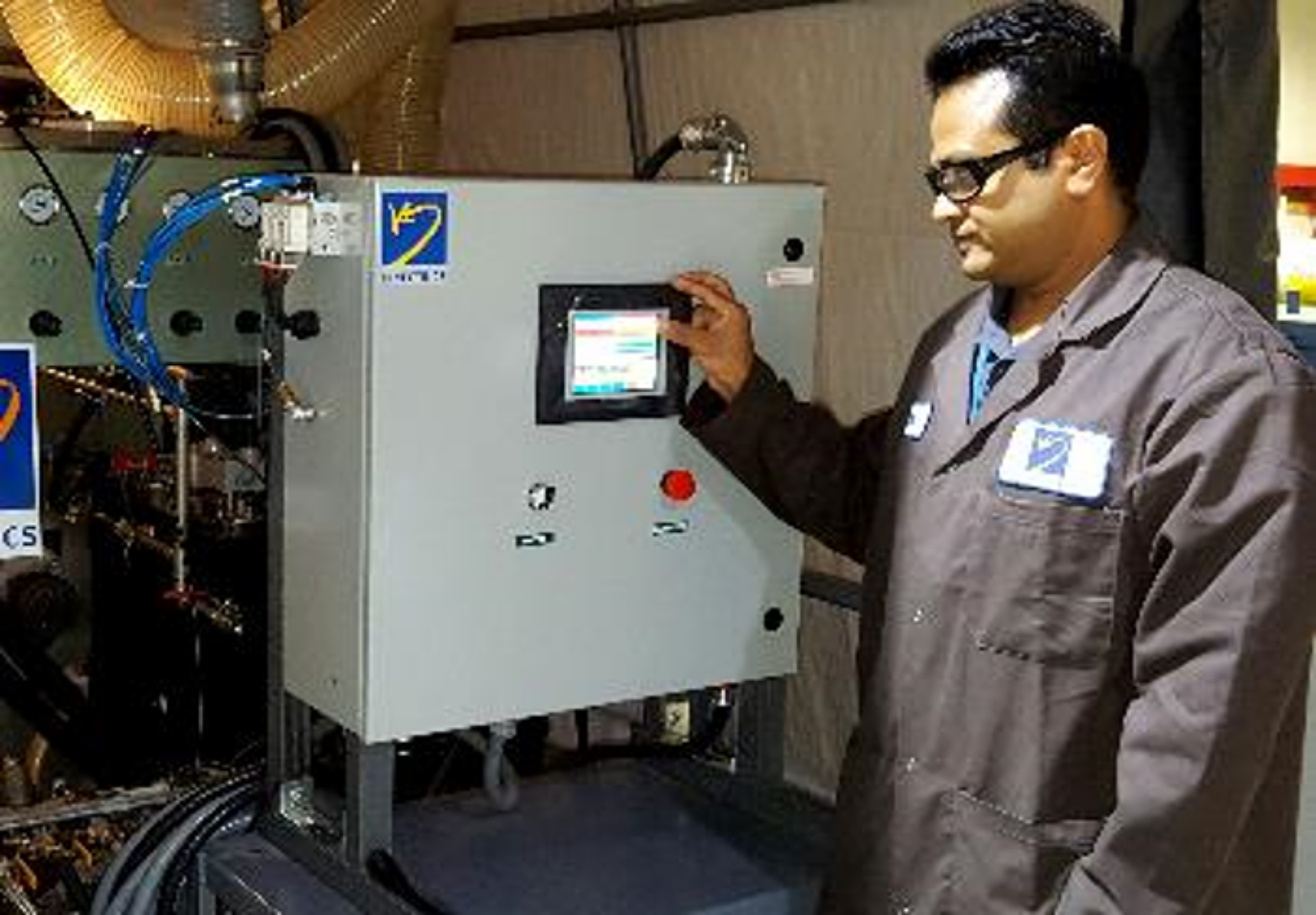 Photograph of a worker configuring a large machine via a touchscreen